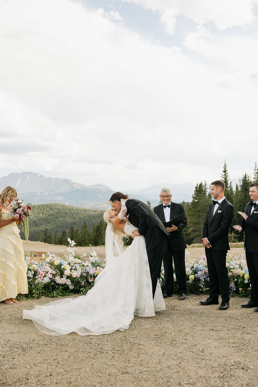 A Christian bride and groom sharing their first kiss after a Christ-centered wedding ceremony, officiated by a pastor in a beautiful outdoor setting